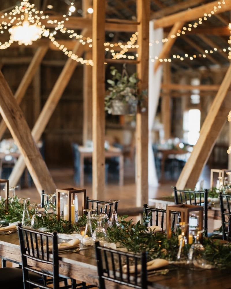Place settings and low floral arrangements running the length of a farm table.