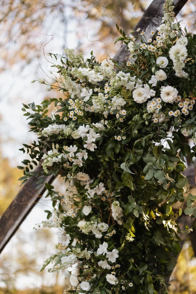 A white floral arrangement on a wooden table.